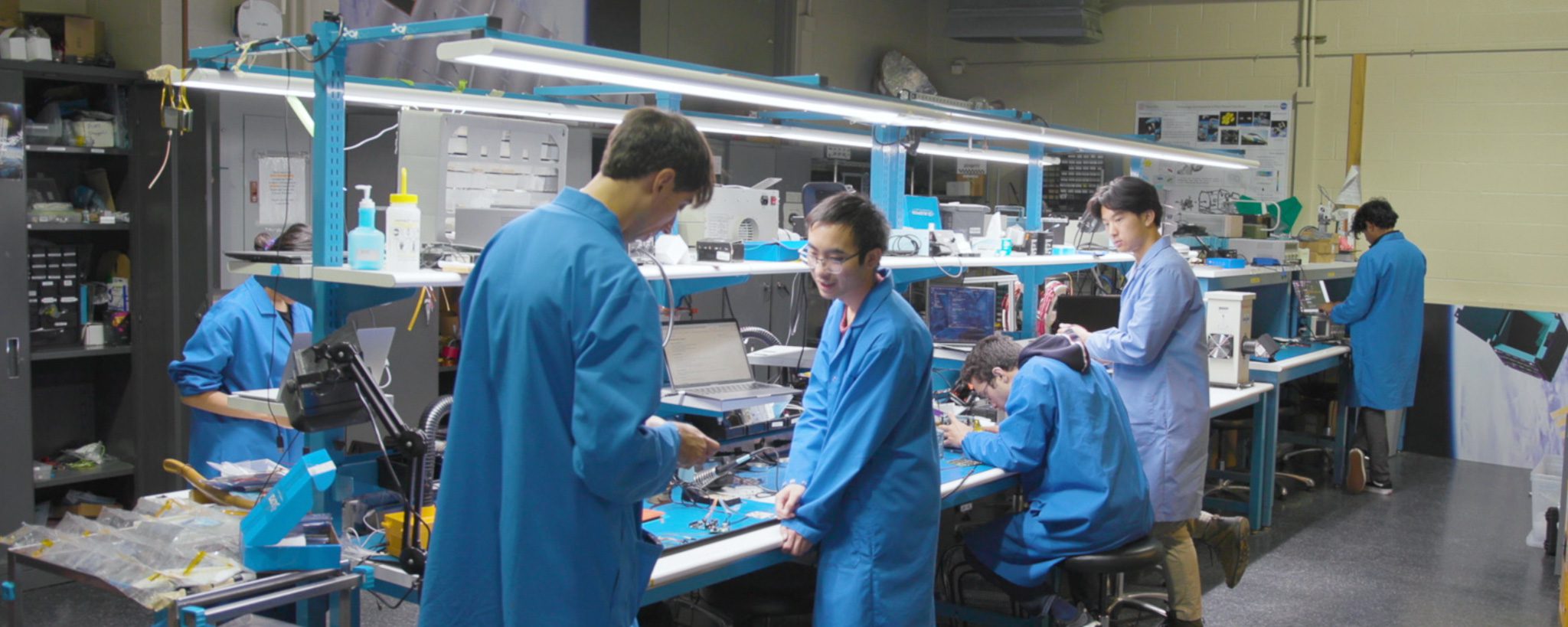 Students working in lab with blue lab coats on